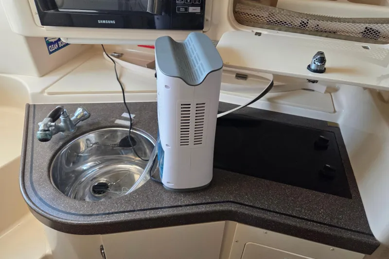 Slide: The Image of 2004 Grady-White Express 330 boat kitchen with sink, microwave, and appliance. - 55