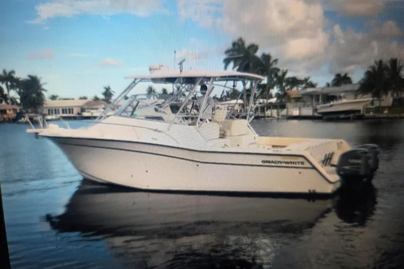 Slide: The Image of 2004 Grady-White Express 330 boat on calm water with palm trees in the background. - 6