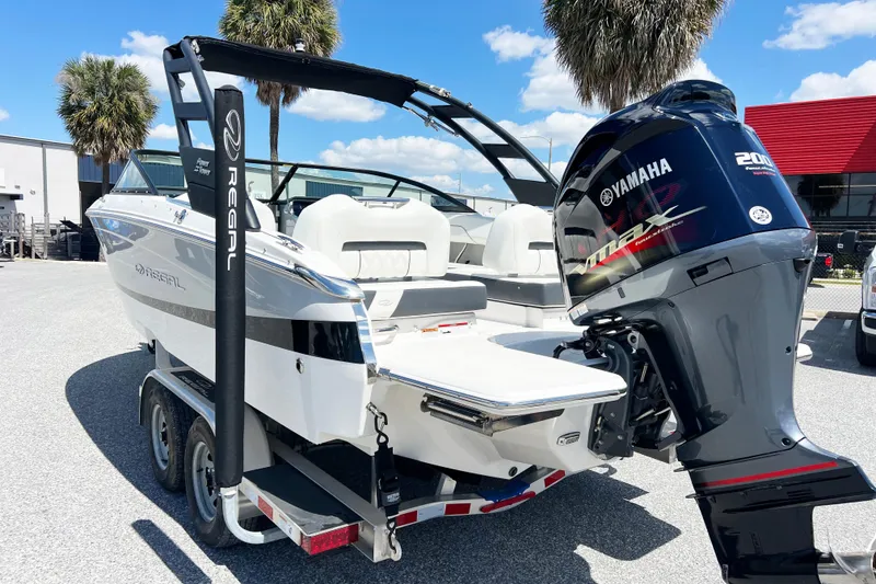 Slide: The Image of 2022 Regal LX2 boat with Yamaha 200 engine, parked outdoors. - 14