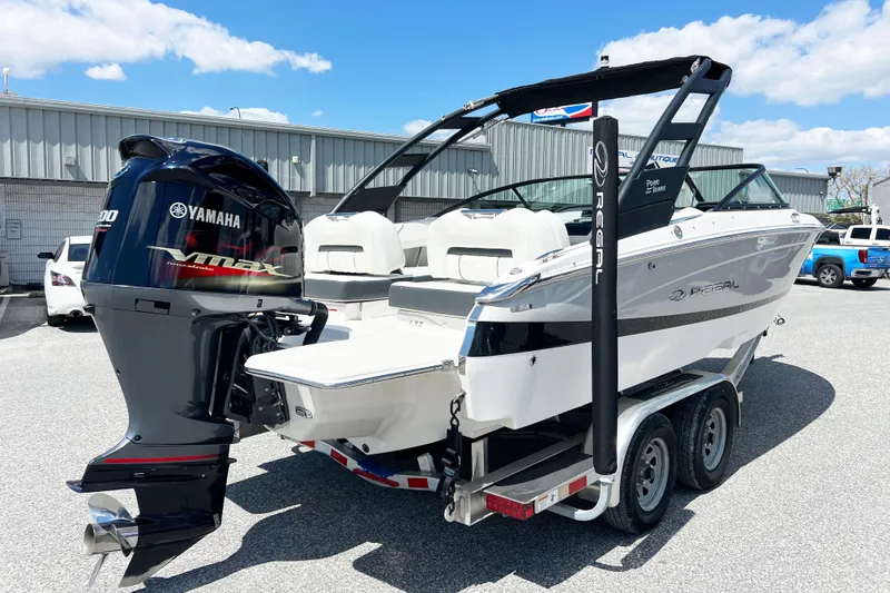 Slide: The Image of 2022 Regal LX2 boat with Yamaha VMAX engine on a trailer, parked outdoors. - 16