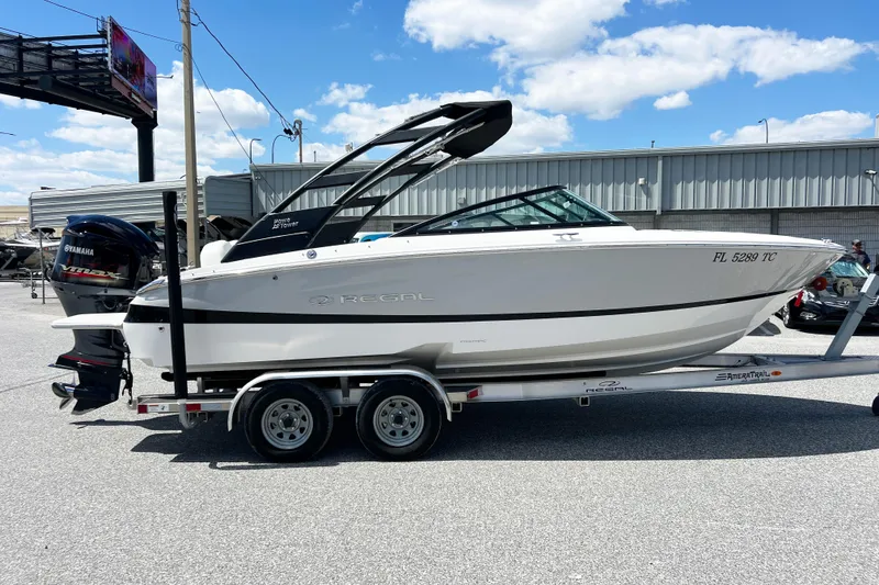 Slide: The Image of 2022 Regal LX2 boat on trailer, featuring Yamaha outboard motor, parked outdoors. - 17