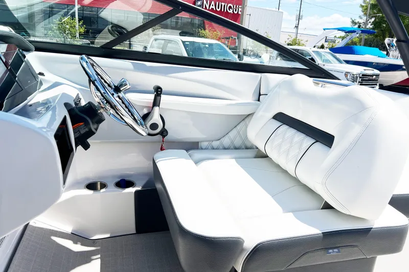 Slide: The Image of Interior of a 2022 Regal LX2 boat with white seating and chrome steering wheel. - 9