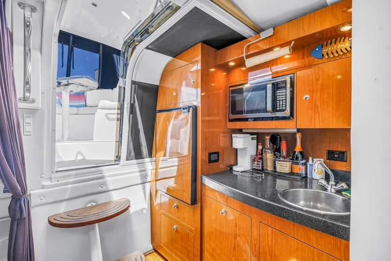 Slide: The Image of 2007 Regal Commodore 3760 IB yacht interior with kitchenette, featuring microwave and sink. - 13