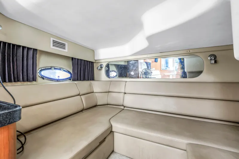 Slide: The Image of Interior of 2007 Regal Commodore 3760 IB yacht with beige seating and porthole windows. - 15