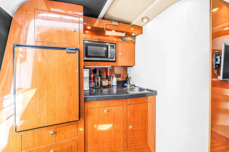 Slide: The Image of 2007 Regal Commodore 3760 IB yacht kitchen with wood cabinetry, microwave, and sink. - 7
