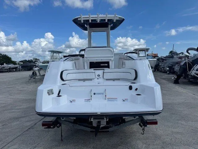 Slide: The Image of Rear view of a 2025 Yamaha 252 FSH Sport boat in a parking lot. - 24