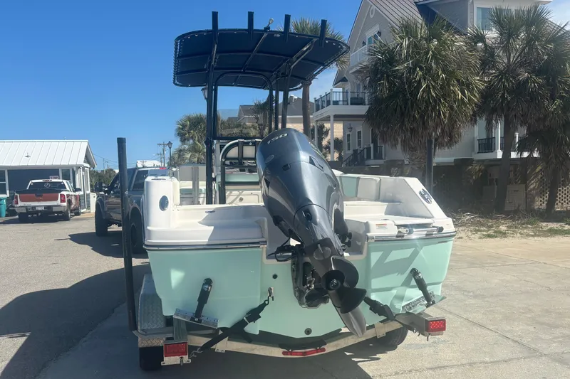 Slide: The Image of 2023 Robalo R200 Center Console boat on trailer, parked near palm trees. - 14