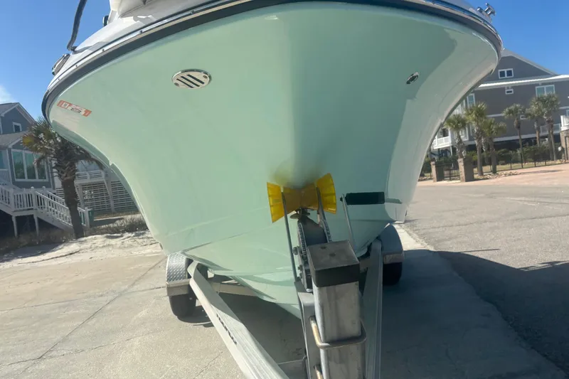 Slide: The Image of 2023 Robalo R200 Center Console boat on trailer, parked near beach houses. - 3