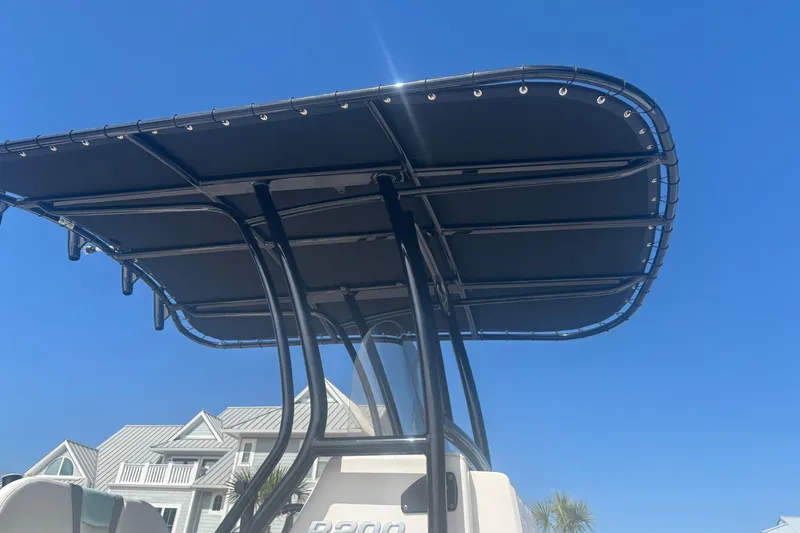 Slide: The Image of 2023 Robalo R200 Center Console boat with T-top against clear blue sky. - 5
