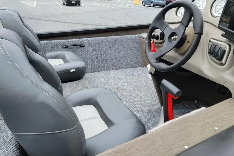 Slide: The Image of 2006 Tracker Pro Team 190 TX boat interior with steering wheel and seats in parking lot. - 7