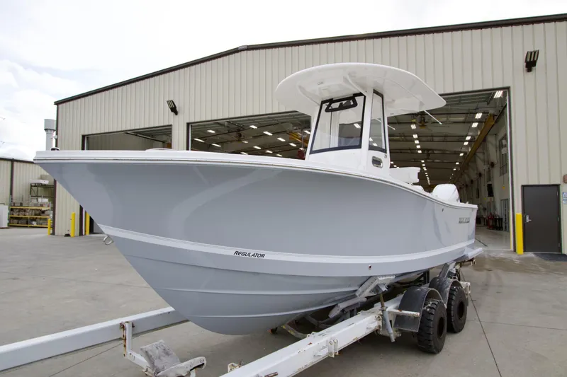 The Image of 2026 Regulator 23 boat on trailer outside a large warehouse. - 0