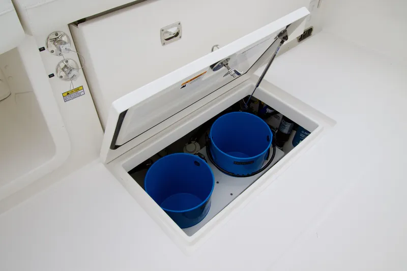 Slide: The Image of Storage compartment on 2026 Regulator 23 boat with blue buckets inside. - 13
