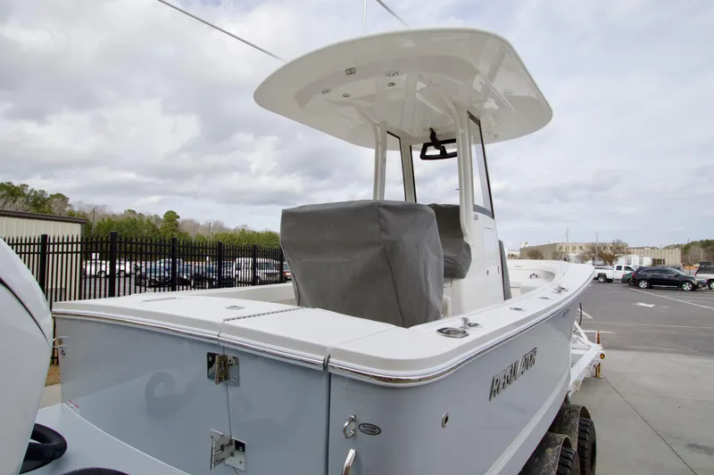 Slide: The Image of 2026 Regulator 23 boat in parking lot, showcasing sleek design and covered console. - 2