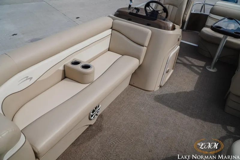 Slide: The Image of 2013 Bennington 20 SL pontoon boat interior with beige seating and steering console. - 13