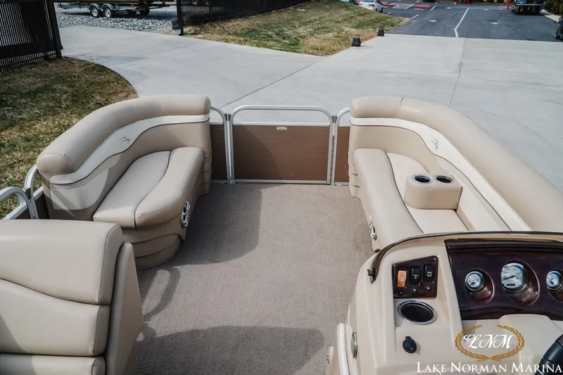 Slide: The Image of 2013 Bennington 20 SL pontoon boat interior with beige seating and control panel. - 8