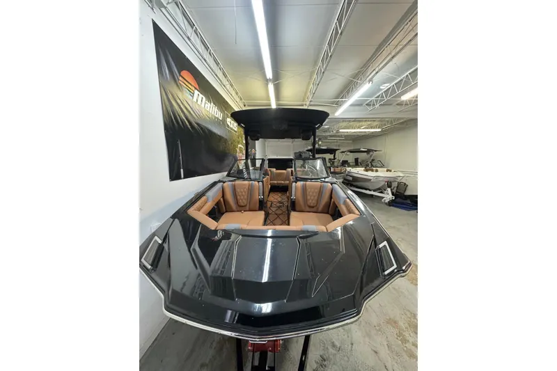 Slide: The Image of 2026 Malibu M230 boat with sleek design and luxurious interior in showroom. - 3