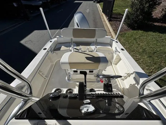 Slide: The Image of 2025 Bulls Bay 200CC boat interior with steering console and seating, parked on a sunny day. - 10