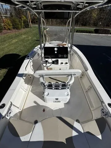 Slide: The Image of 2025 Bulls Bay 200CC boat interior with steering console and seating, docked outdoors. - 4