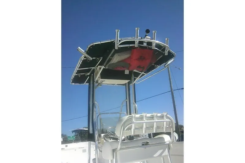 Slide: The Image of 2011 Carolina Skiff 258 DLV boat with T-top and rod holders against clear blue sky. - 12