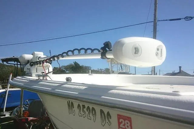 Slide: The Image of 2011 Carolina Skiff 258 DLV with trolling motor, docked under clear blue sky. - 14