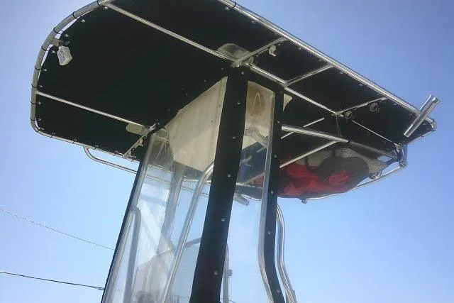 Slide: The Image of 2011 Carolina Skiff 258 DLV boat with T-top canopy against clear sky. - 15
