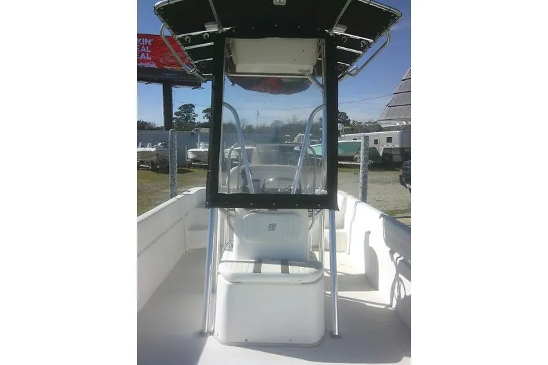 Slide: The Image of 2011 Carolina Skiff 258 DLV boat with center console and T-top in a marina setting. - 19
