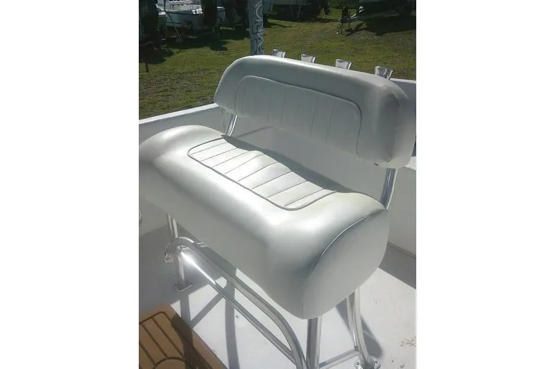 Slide: The Image of 2011 Carolina Skiff 258 DLV boat seat with white cushioned upholstery and metal frame. - 22