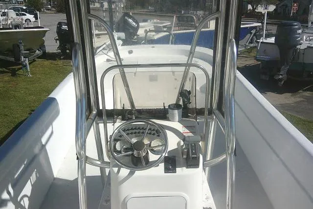 Slide: The Image of 2011 Carolina Skiff 258 DLV boat with center console and steering wheel, docked outdoors. - 30