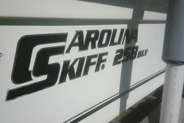 Slide: The Image of 2011 Carolina Skiff 258 DLV boat logo on white hull. - 7