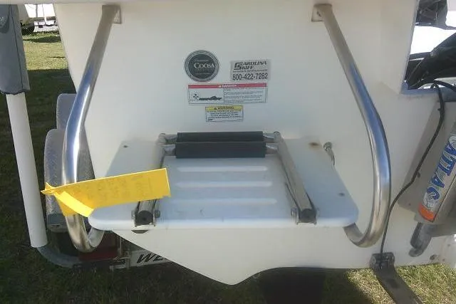 Slide: The Image of 2011 Carolina Skiff 258 DLV boat ladder and safety labels on the stern. - 9