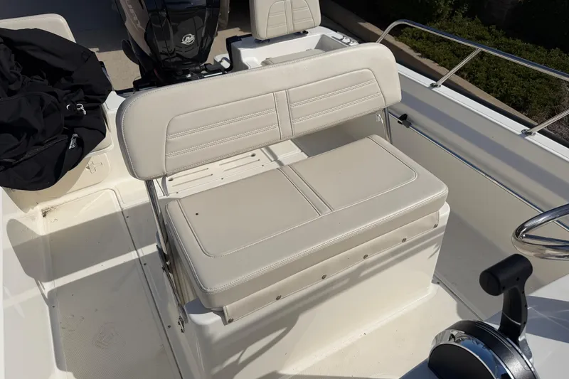 Slide: The Image of 2020 Boston Whaler 170 Montauk boat interior with cushioned seating and steering controls. - 8