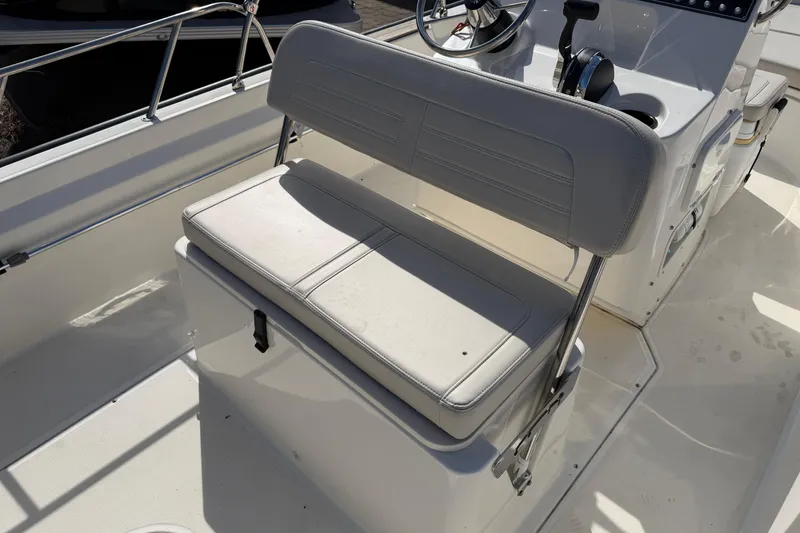 Slide: The Image of 2020 Boston Whaler 170 Montauk boat interior with cushioned seating and steering console. - 9
