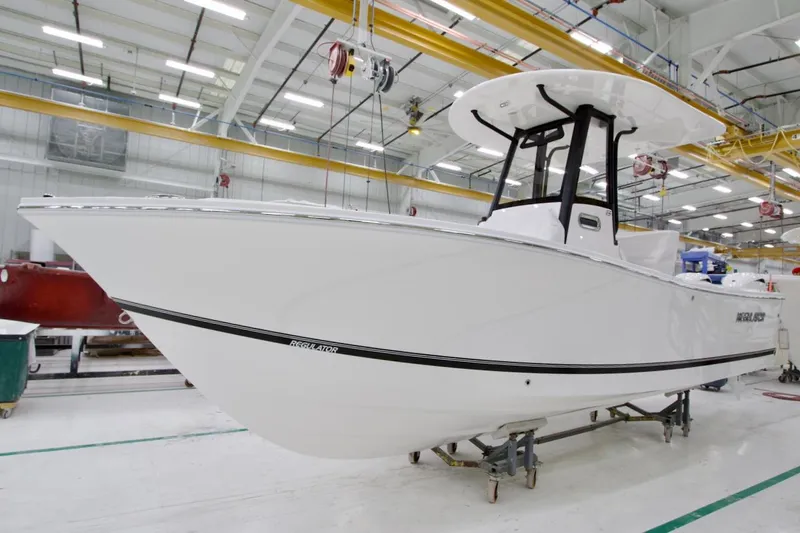 The Image of 2026 Regulator 23 boat in a manufacturing facility, showcasing sleek design and craftsmanship. - 0