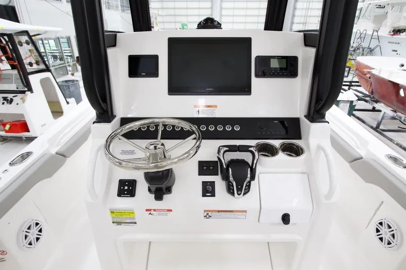 Slide: The Image of 2026 Regulator 23 boat dashboard with steering wheel, controls, and display screens. - 12