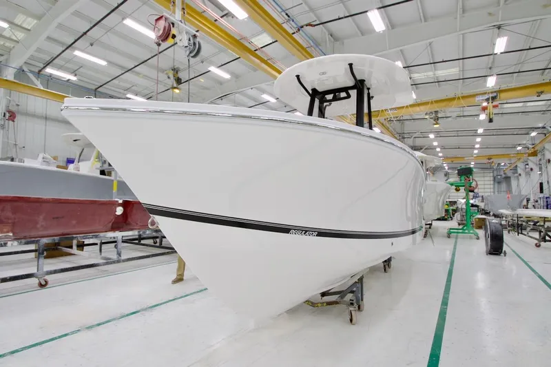 Slide: The Image of 2026 Regulator 23 boat in a manufacturing facility, showcasing sleek design and craftsmanship. - 2