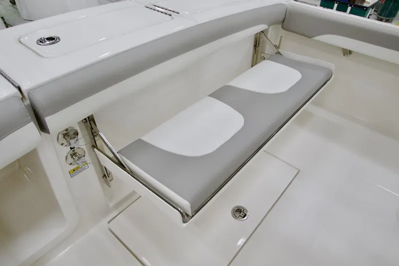 Slide: The Image of 2026 Regulator 23 boat with foldable gray and white cushioned seating. - 21