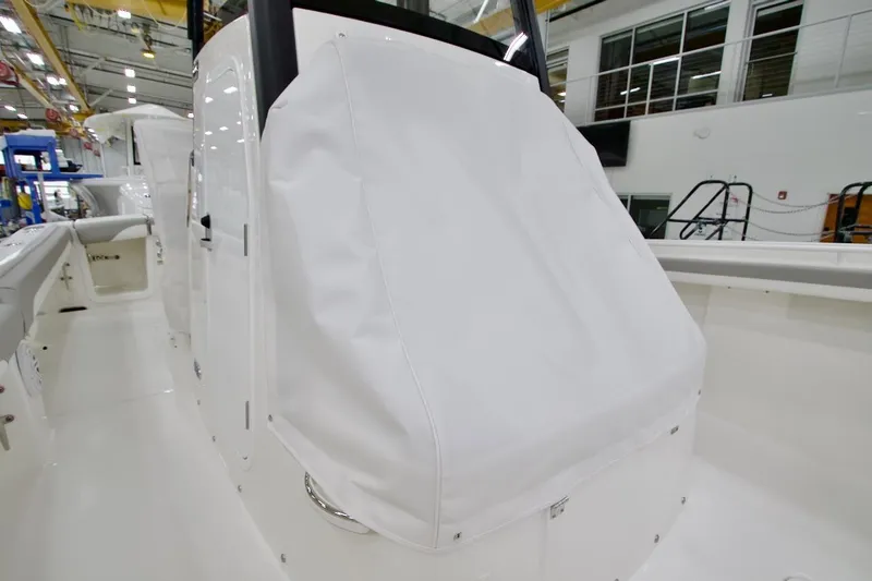 Slide: The Image of 2026 Regulator 23 boat interior with covered console in a showroom. - 25