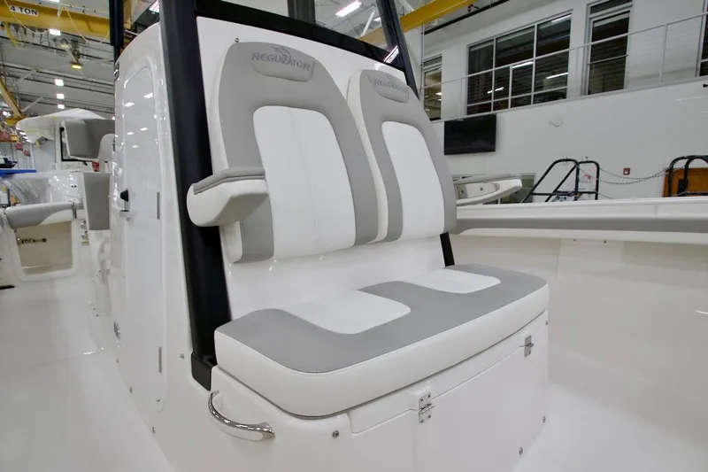 Slide: The Image of 2026 Regulator 23 boat interior with cushioned seating in a showroom. - 27