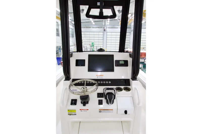 Slide: The Image of 2026 Regulator 23 boat console with steering wheel, digital display, and controls in a bright interior. - 31
