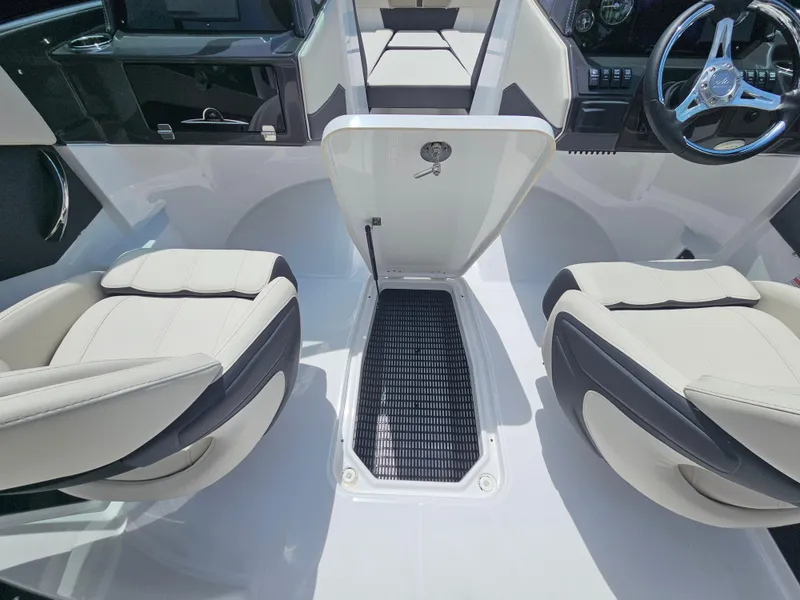 Slide: The Image of 2025 Monterey M-225 boat interior with two cushioned seats and central storage compartment. - 17