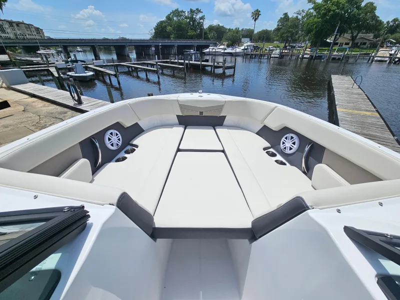 Slide: The Image of 2025 Monterey M-225 boat interior with spacious seating at a marina. - 18