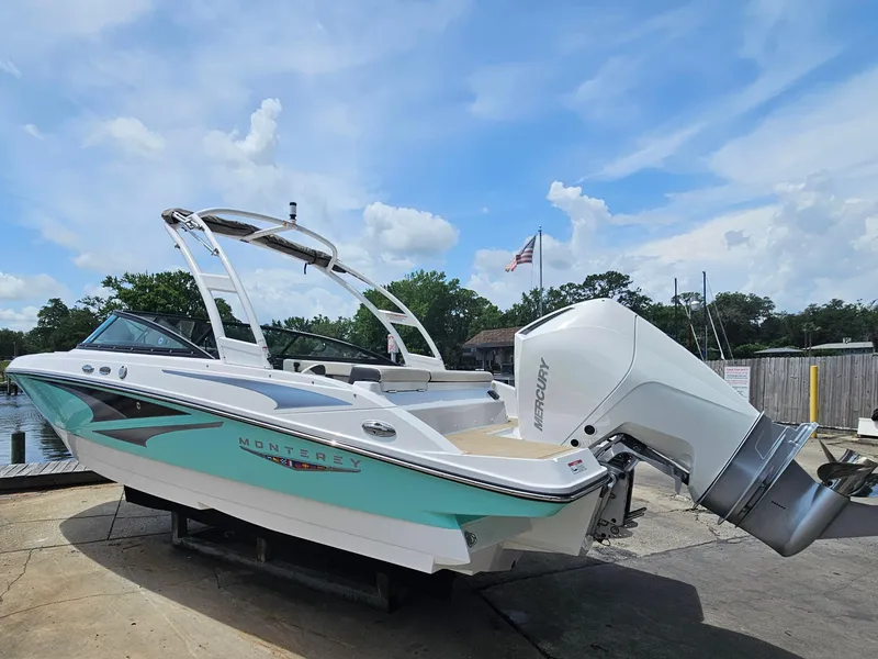 Slide: The Image of 2025 Monterey M-225 boat with Mercury engine, docked under a clear blue sky. - 2