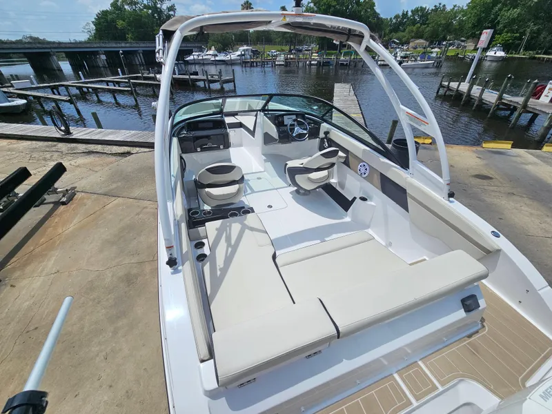 Slide: The Image of 2025 Monterey M-225 boat with spacious seating, docked by a serene waterfront. - 7