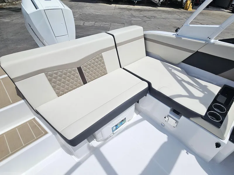 Slide: The Image of 2025 Monterey M-225 boat interior with beige seating and cup holders. - 9
