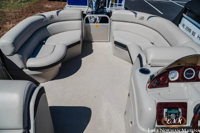 Slide: The Image of 2013 Berkshire 190CL pontoon boat interior with plush seating and control panel. - 8