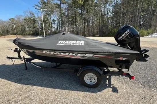 Slide: The Image of 2025 Tracker Super Guide V-16 SC boat with cover and Mercury engine in a wooded area. - 10