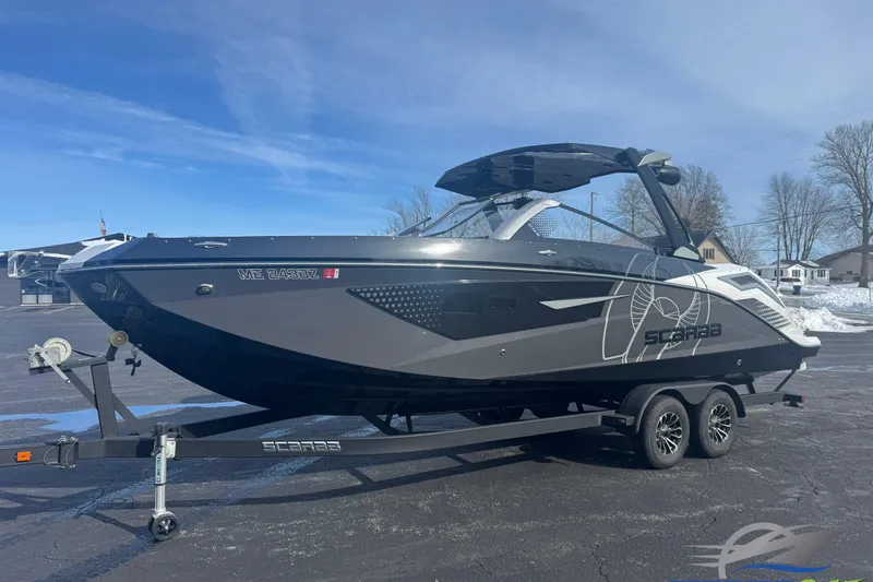 The Image of 2021 Scarab 285 ID boat on trailer, parked outdoors under clear blue sky. - 0