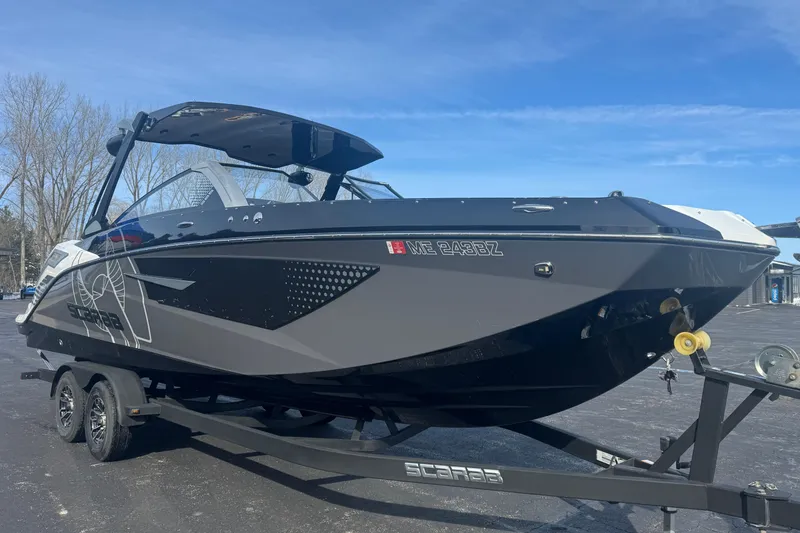Slide: The Image of 2021 Scarab 285 ID boat on trailer, parked outdoors under clear blue sky. - 5