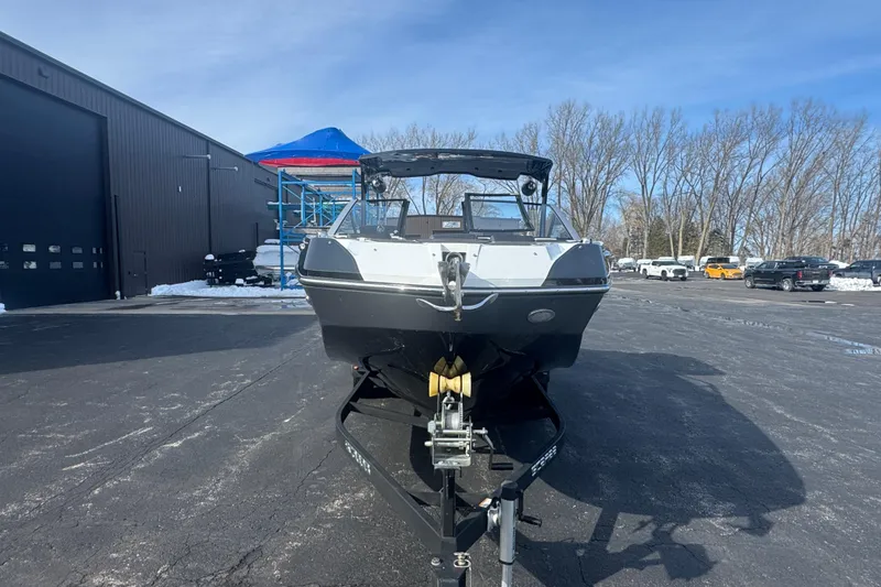 Slide: The Image of 2021 Scarab 285 ID boat on trailer in parking lot, clear sky background. - 6