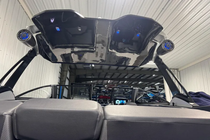 Slide: The Image of 2021 Scarab 285 ID boat interior with speakers and sleek design in a garage setting. - 8